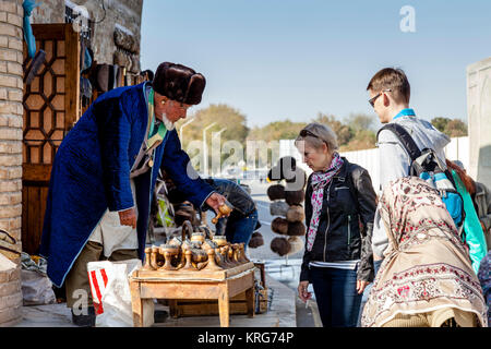 Un vieil homme ouzbèkes vend des souvenirs d'un décrochage dans le marché, Boukhara, Ouzbékistan Banque D'Images