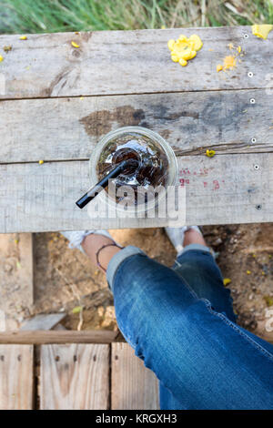 Jambe avec jean fille asiatique vous détendre de temps avec boisson froide sur table en bois dans la nature vie Banque D'Images