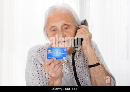 Avec carte de crédit Senior Woman On Phone Banque D'Images