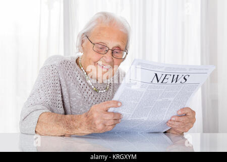 Senior Woman Reading Newspaper Banque D'Images