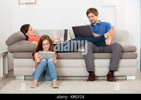 Girl Sitting on Carpet Using Digital Tablet Banque D'Images