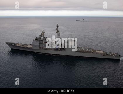 La marine américaine de classe Ticonderoga croiseur lance-missiles USS Bunker Hill (avant) le long de la manœuvre de l'Armée de Libération Populaire Chinois Jiangkai II-classe frégate lance-missiles Daqing au large de la côte de Californie du Sud, le 9 décembre 2016 dans l'océan Pacifique. Banque D'Images