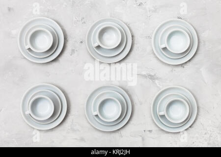 Vue supérieure de six tasses et soucoupes blanc sur le béton Banque D'Images