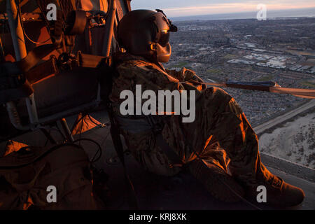 Le Sgt. Anthony Orduno, un UH-60 Black Hawk chef d'équipage de la Garde nationale de Californie est la Compagnie B, 1er Bataillon, 140e Régiment d'aviation, donne de l'hélicoptère, tout en volant retour à l'aéroport de Camarillo de Camarillo, en Californie, après avoir fait une série de gouttes d'eau sur le feu Thomas dans le comté de Ventura, Samedi, Décembre 9, 2017, dans le comté de Ventura, en Californie. Orduno et l'équipage de l'hélicoptère a passé la journée laissant tomber l'eau sur le feu en coordination avec CAL FIRE et conclu leurs opérations de lutte contre les incendies autour de coucher du soleil. (U.S. Air National Guard Banque D'Images