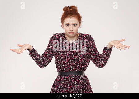 Des émotions négatives, les expressions du visage, perception et l'attitude de la vie. Perplexe redhead woman with arms out, haussant les épaules. Stu isolés Banque D'Images