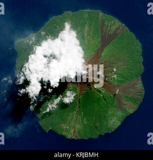 NASA image acquise le 16 juin 2010. La Papouasie-Nouvelle-Guinée, le volcan Manam a publié une fine plume légère, le 16 juin 2010, que les nuages au sommet du volcan. L'Advanced Land Imager (ALI) sur l'observation de la terre de la NASA-1 (EO-1) a pris cette photo le jour même. Les Ruisseaux de brown rock interrompre le tapis de végétation verte sur les pentes du volcan. Les nuages blancs opaques masquent partiellement la vue du satellite de Manam. Les nuages peuvent résulter de la vapeur d'eau du volcan, mais peuvent aussi avoir formé indépendamment de l'activité volcanique. Le panache volcanique apparaît comme un fin voile bleu-gris exte Banque D'Images