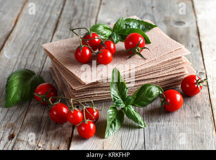 Matières les feuilles de lasagne et tomates cerises Banque D'Images