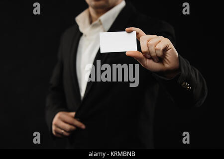 L'homme d'affaires en costume noir montrant une carte de crédit ou carte de visite Banque D'Images