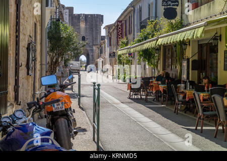 Quartier calme ensoleillée à Aigues-Mortes avec café en plein air, et tour de ville en arrière-plan. Aigues-Mortes, France du sud. 2017. Banque D'Images