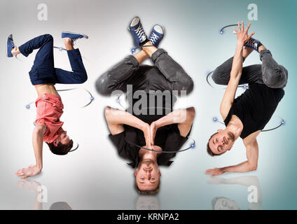 Break dancers doing handstand against white background Banque D'Images