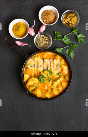 Poulet au curry sur pierre sombre arrière-plan avec copie espace. Vue de dessus, de l'alimentation mise à plat Banque D'Images