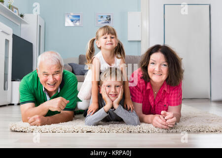 Portrait de Multi Generation Family Lying On Carpet Banque D'Images