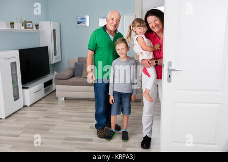 Les grands-parents et petits-enfants debout derrière la porte Banque D'Images