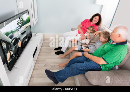 Playing Videogame avec ses grands-parents à la maison Banque D'Images