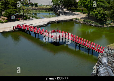 Matsumoto - le Japon, le 6 juin 2017 : Rouge pont sur les douves du Château de Matsumoto, également connu sous le nom de Château-de-Corbeau. Banque D'Images