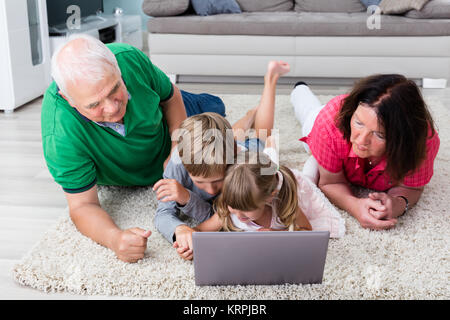 Multi Generation Family Using Laptop At Home Banque D'Images