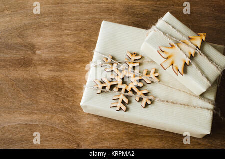 Cadeaux de Noël avec les boîtes Kraft décorée en style rustique sur fond de bois. Banque D'Images