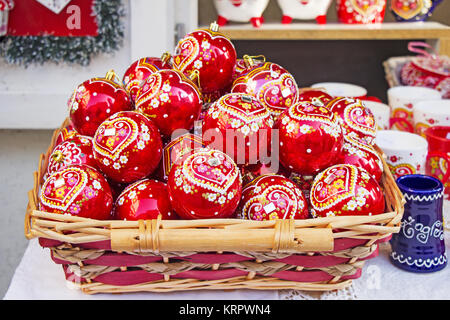 Boules de Noël rouge dans panier en osier, peints à la main avec des décorations traditionnelles croates Banque D'Images