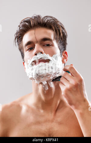 Jeune homme séduisant est de sa barbe. Banque D'Images
