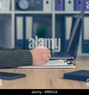 Femme freelancer typing while looking at laptop computer Banque D'Images