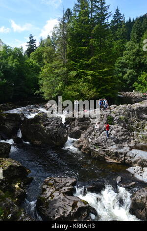 Les gens d'escalade sur les rochers, à Betws-Y-Coed Cascade, rivière Conwy, vallée de Conwy, Galles, Royaume-Uni. Banque D'Images