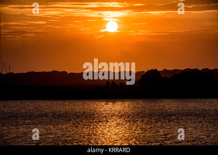 Coucher de soleil sur l'océan Atlantique Sullivan's Island Caroline du Sud // SULLIVAN'S ISLAND, Caroline du Sud — le soleil se couche sur l'océan Atlantique à Sullivan's Island, projetant une lumière dorée à travers l'horizon. Située à environ six miles à l'est de Charleston, Sullivan's Island est une île barrière connue pour ses plages immaculées et son importance historique. L'île de 3,3 kilomètres carrés comprend un phare, Fort Moultrie (qui fait partie du monument national Fort Sumter) et des paysages côtiers naturels. Sullivan's Island a joué un rôle dans l'histoire de la révolution et de la guerre de Sécession et reste une destination populaire pour Banque D'Images