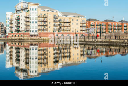 Nouveaux appartements dans la baie de Cardiff, reflétée dans l'eau de l'ancien dock, Nouvelle-Galles du Sud Banque D'Images