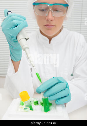 Jeune femme scientifique ou technique fonctionne avec une pipette automatique Banque D'Images