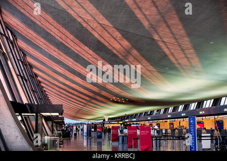 Intérieur du terminal de l'aéroport international de Dulles Chantilly Virginie // DULLES, Virginie — la lumière du soleil coule en fin d'après-midi à travers de grandes fenêtres vitrées sur le plafond du terminal original en forme d'aile de l'aéroport international de Dulles à Chantilly, Virginie. Conçu par le célèbre architecte Eero Saarinen et inauguré en 1962, le terminal principal est connu pour son design distinctif de toit panoramique. Dulles est l'un des trois principaux aéroports de la région métropolitaine de Washington DC, gérant les vols intérieurs et internationaux. La structure moderniste est considérée comme un terrain architectural Banque D'Images