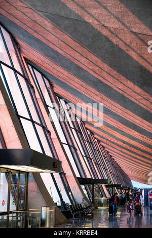 Intérieur du terminal de l'aéroport international de Dulles Chantilly Virginie // DULLES, Virginie — la lumière du soleil coule en fin d'après-midi à travers de grandes fenêtres vitrées sur le plafond du terminal original en forme d'aile de l'aéroport international de Dulles à Chantilly, Virginie. Conçu par le célèbre architecte Eero Saarinen et inauguré en 1962, le terminal principal est connu pour son design distinctif de toit panoramique. Dulles est l'un des trois principaux aéroports de la région métropolitaine de Washington DC, gérant les vols intérieurs et internationaux. La structure moderniste est considérée comme un terrain architectural Banque D'Images