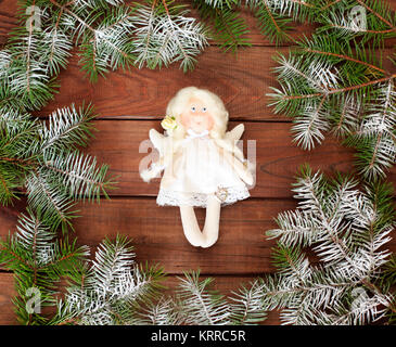 Tissu blanc ange sur un fond de bois en sapin de Noël. - Textile souple, toy doll. Carte postale. Décorations de Noël. Banque D'Images