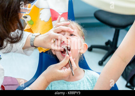 Enfant d'âge préscolaire est au bureau de dentiste, la préparation pour enlever les dents de lait. Banque D'Images