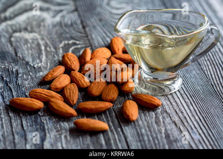 L'huile d'amande douce dans un bocal en verre et amandes Banque D'Images