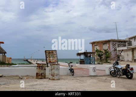 Un vélo et une moto garée près d'une jetée et de vieux sentiers battus météo maisons près de Progesso Yucatan Mexique 7 - 06 - 2017 Banque D'Images