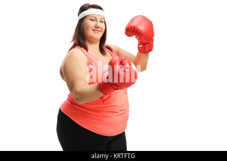 Surpoids femme posant avec une paire de gants de boxe rouge isolé sur fond blanc Banque D'Images