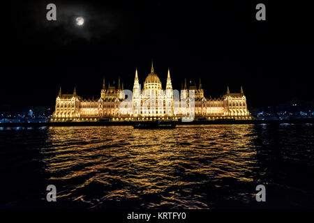 Une croisière de fin de nuit le long du Danube à Budapest Hongrie sous une pleine lune avec le bâtiment du parlement de Budapest illuminée Banque D'Images