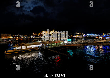 Croisière de fin de nuit le long du Danube à Budapest en Hongrie avec une croisière-excursion bateau et le quartier du château illuminé dans la distance Banque D'Images