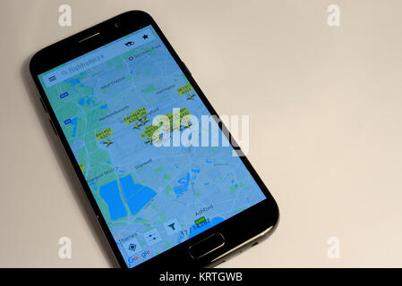 FR 24 Flightradar24 Suivre le vol sur un smart mobile phone montrant le trafic aérien autour de l'aéroport Heathrow de Londres, Royaume-Uni. Fond uni Banque D'Images