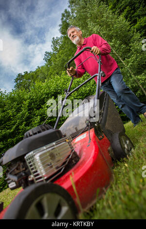 Man tondre la pelouse de son jardin Banque D'Images