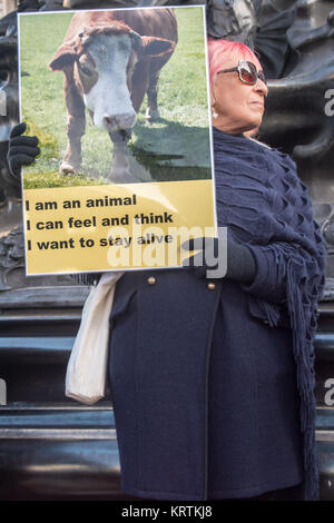 Une femme est titulaire d'un végétalien affiche montrant un veau avec le message 'Je suis animal - je peux sentir et penser - je veux rester en vie" à la base de l'Éros à Piccadilly Circus Banque D'Images