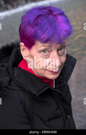 Portrait de posé une jolie femme dans son très jeune au début des années 60 avec les cheveux violet et rouge. À Midtown Manhattan, New York. Banque D'Images