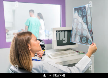 Agréable confiant médecin travaillant pour les résultats de l'analyse de l'IRM Banque D'Images