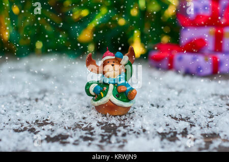 Jouets de Noël en céramique elk en vêtements de fête, debout dans la neige, la neige sur le haut de jette Banque D'Images