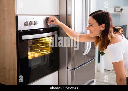 Femme à l'aide d'un four micro-ondes four dans la cuisine Banque D'Images