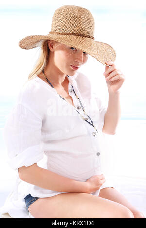 Femme enceinte se reposant sur la plage. Banque D'Images