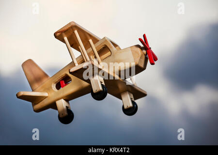 Avion en bois volant sous le ciel d'orage - qui monte Banque D'Images