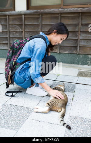 Jeune femme jouer avec cat street Banque D'Images