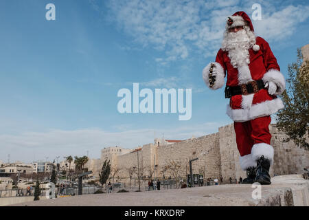 Jérusalem, Israël. 21 Décembre, 2017. Santa Claus, ou 'Baba Noel' comme il est appelé en arabe, marche sur les murs de la vieille ville, donnant sur Jérusalem. La municipalité de Jérusalem et le Fonds National Juif cultivé spécialement distribués cyprès de l'Arizona les arbres de Noël à la population chrétienne à la porte de Jaffa. Credit : Alon Nir/Alamy Live News Banque D'Images