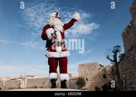 Jérusalem, Israël. 21 Décembre, 2017. Santa Claus, ou 'Baba Noel' comme il est appelé en arabe, marche sur les murs de la vieille ville, donnant sur Jérusalem. La municipalité de Jérusalem et le Fonds National Juif cultivé spécialement distribués cyprès de l'Arizona les arbres de Noël à la population chrétienne à la porte de Jaffa. Credit : Alon Nir/Alamy Live News Banque D'Images