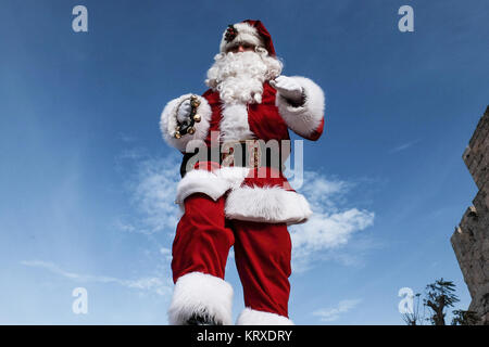 Jérusalem, Israël. 21 Décembre, 2017. Santa Claus, ou 'Baba Noel' comme il est appelé en arabe, marche sur les murs de la vieille ville, donnant sur Jérusalem. La municipalité de Jérusalem et le Fonds National Juif cultivé spécialement distribués cyprès de l'Arizona les arbres de Noël à la population chrétienne à la porte de Jaffa. Credit : Alon Nir/Alamy Live News Banque D'Images